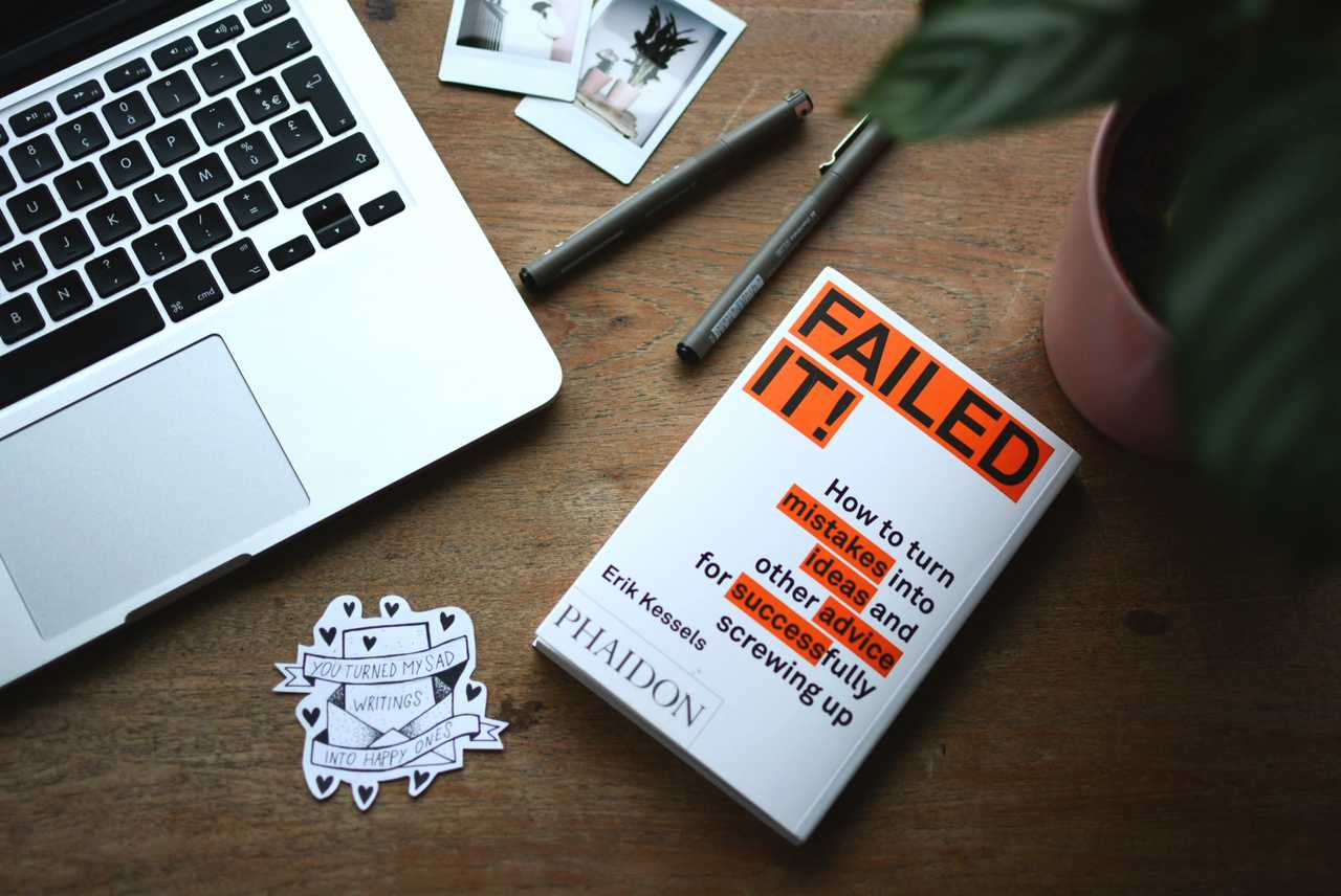 "Failed It!" book on desk near laptop